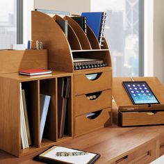 a wooden desk with drawers and a tablet on it