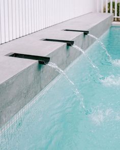 an outdoor swimming pool with water spouting from it