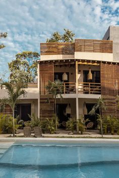 a large building with wooden balconies next to a swimming pool