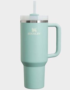 the stanley travel mug is light blue and has a straw in it