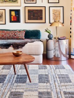 a living room filled with furniture and framed pictures on the wall above it's coffee table