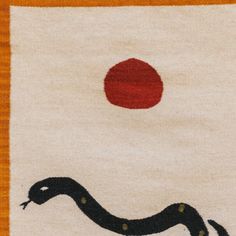 a rug with a black snake on it and a red dot in the middle,