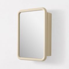 a mirror mounted to the side of a wall next to a light switch on a white wall