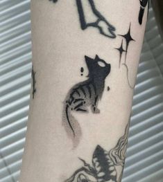 a black and white cat tattoo on the arm