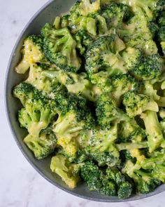 a bowl filled with broccoli on top of a white counter