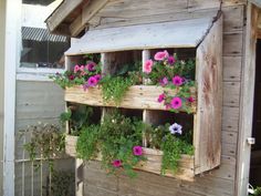 a wooden building with flowers growing in it's windowsill and attached to the side