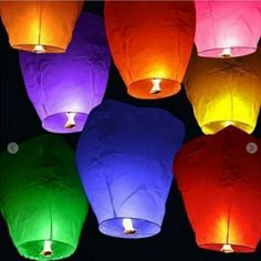 many colorful lanterns are lit up in the dark