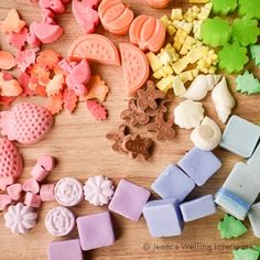 several different colored candies on a wooden table