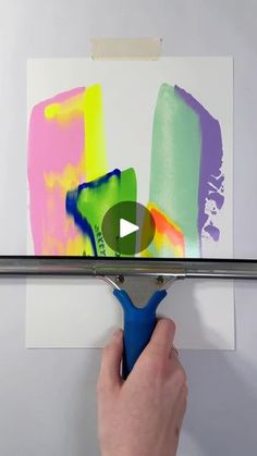 a person is using a paint roller to create an abstract painting on the wall with acrylic colors