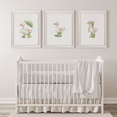 three framed pictures hang on the wall above a crib