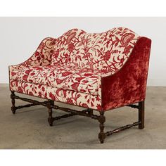 a red and white couch sitting on top of a cement floor