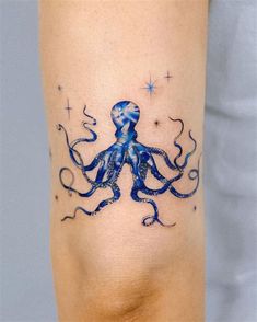 an octopus tattoo on the leg with blue watercolors and stars in the background