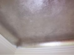 the corner of a room that has been painted silver with white trim and mold on it