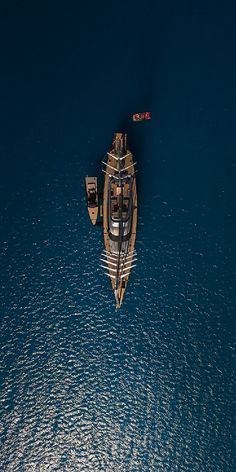 an aerial view of a boat in the ocean with two smaller boats on it's side