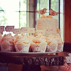 cupcakes are displayed on a cake plate in front of the table with place cards