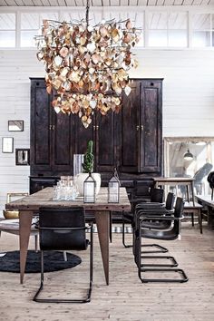 a dining room table with chairs and a chandelier hanging from it's ceiling