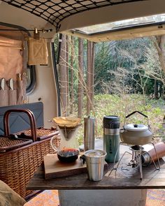 a table with food and drinks on it in front of an open door to a wooded area