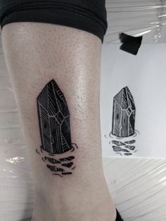 a person with a tattoo on their leg that has two rocks in the water and one is