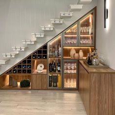 the wine cellar under the stairs is filled with bottles, glasses, and other items