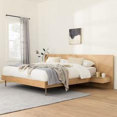 a bed sitting on top of a hard wood floor next to a white wall in a bedroom