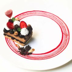 a piece of cake sitting on top of a white plate covered in chocolate and strawberries