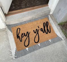 a door mat that says hey y'all on the front porch with black letters