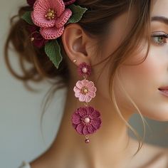 a woman with flowers in her hair is wearing earrings made out of crochet