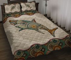 a bed covered in a quilt with a shark on it