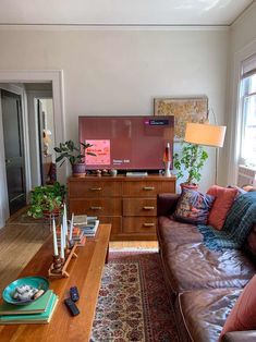 a living room filled with furniture and a flat screen tv on top of a wooden table