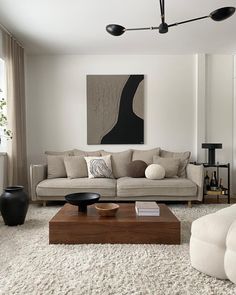 a living room filled with furniture and a painting on the wall