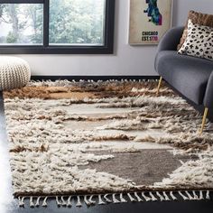 a living room with a large rug on the floor next to a chair and window