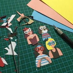 paper cut outs are laid out on a table with scissors and other crafting supplies