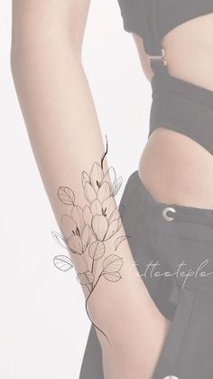 a woman's arm with flowers on it and the word tattoo written in black ink