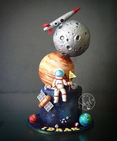 a cake that has an astronaut on top of it with the moon in the background