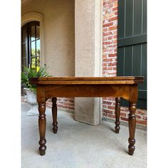 a wooden table sitting in front of a brick building