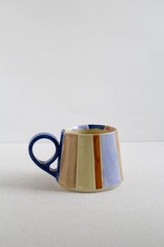 a blue and brown striped coffee cup on a white surface