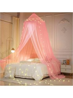 a pink canopy bed with fairy lights on it