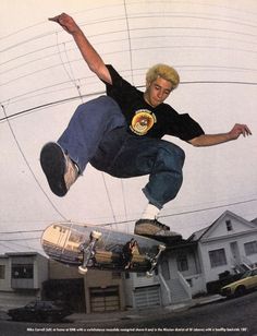 a man flying through the air while riding a skateboard in front of a house