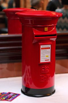 a red mailbox sitting on top of a white table