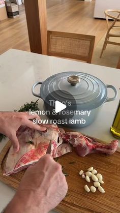 a person cutting up meat on top of a wooden cutting board