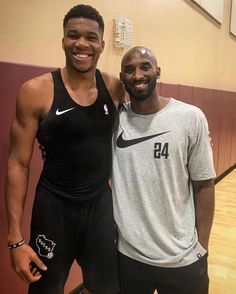 two men standing next to each other on a basketball court