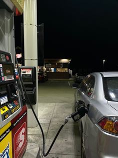 a silver car at a gas station with an electric fuel pump