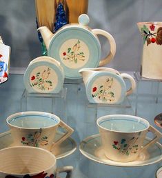 there are many cups and saucers on display