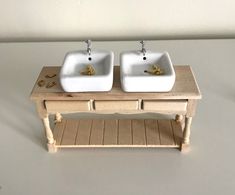 two white sinks sitting on top of a wooden table