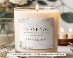 a candle with a thank you label on it sitting next to some flowers and candles