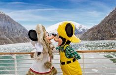 two people dressed as mickey mouse and goofy duck on a cruise ship in the water