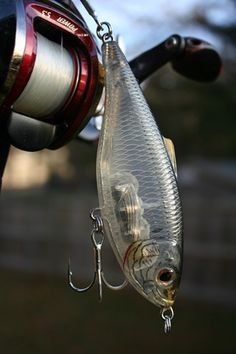 a fishing lure hanging from the side of a boat with a reel attached to it