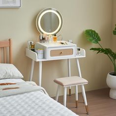 a white vanity table with a mirror and stool in front of it next to a bed