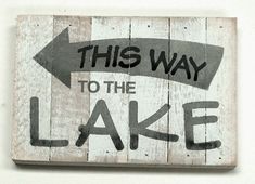 this way to the lake is painted on wooden planks with an arrow pointing up