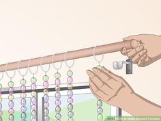 two hands are holding onto a curtain rod with beads hanging from it and another hand is reaching for the bead